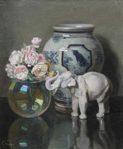 Jules Alexandre Grun: STILL LIFE WITH URN, PORCELAIN ELEPHANT AND ROSES IN A GLASS BOWL